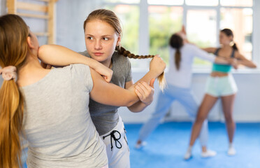 Two teenage girls training in group self-defense classes
