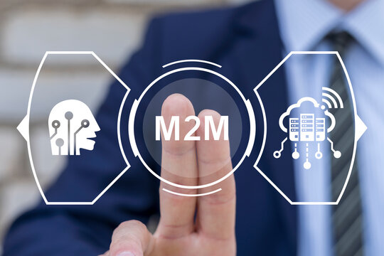 Business man using virtual touch screen presses abbreviation: M2M. M2M Machine-to-Machine Business Industry concept. Machine to Machine Smart Production Artificial Intelligence technology.