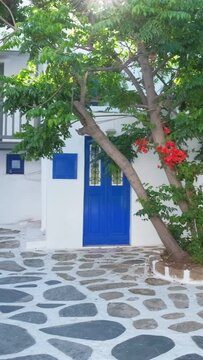 Picturesque scenic narrow streets with traditional whitewashed houses with blue doors windows of Mykonos town in famous tourist attraction Mykonos island, Greece. Horizontal camera pan