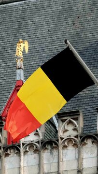 Flag of Flanders, called the Vlaamse Leeuw (Flemish Lion), is the flag of the Flemish Community and Flemish Region and Belgium flag on old gothic building waving in the wind. Brugge Bruges, Belgium