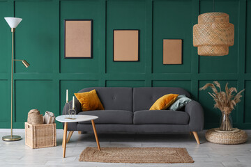 Stylish interior of green living room with cozy sofa, coffee table and carpet - obrazy, fototapety, plakaty