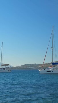 Sunset in Mykonos island, Greece with yachts in the harbor and colorful waterfront houses of Little Venice romantic spot. Mykonos town, Greece. Horizontal camera pan