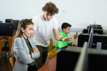 Teacher shows the student how to solve the problem on the computer - obrazy, fototapety, plakaty
