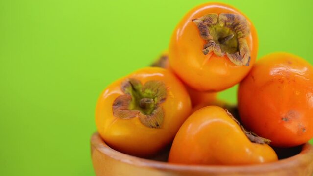 beautiful ripe persimmon in wooden plate