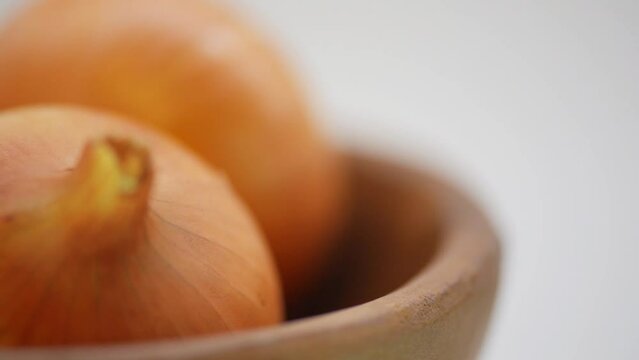 Brown onions in wooden plate