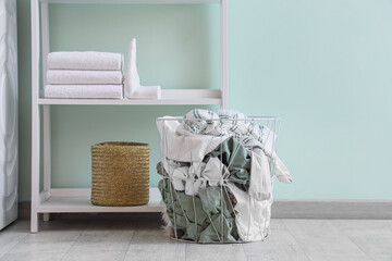 Laundry basket near shelf unit in room