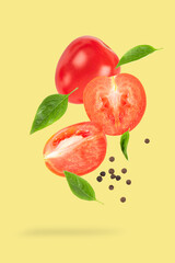 Falling tomato with half and leaves on yellow background. - 787617896
