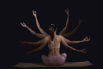 Young woman in sportswear practicing yoga in motion on black background, back view