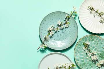Beautiful table setting with blossoming branches on turquoise background