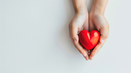 Cupped Hands Gently Holding a Glossy Red Heart, Symbolizing Care and Compassion on a Neutral Background