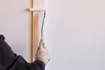 Home renovation, worker painting wooden door