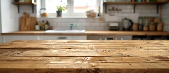 Wooden table with no items on it and a blurred background of a kitchen counter.