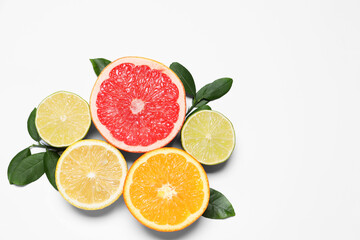 Different cut citrus fruits and leaves on white table, flat lay. Space for text