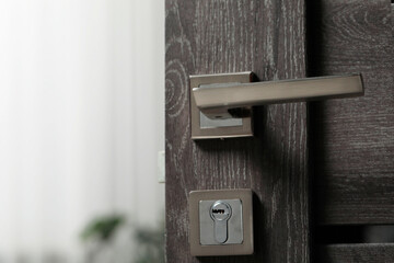 Open wooden door with metal handle, closeup