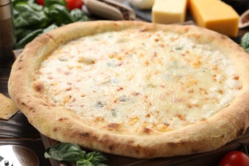 Delicious cheese pizza and ingredients on wooden table, closeup