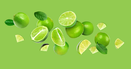 Fresh ripe limes in air on light green background