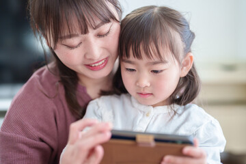 スマートフォンを使う親子　女の子とお母さん - 787659213