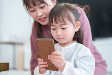 スマートフォンを使う親子　女の子とお母さん - 787659281