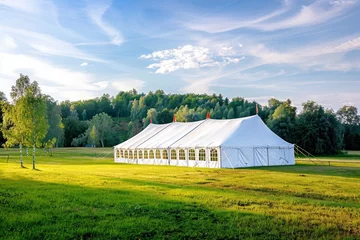 Foto auf Acrylglas An oversized white tent for a nature wedding with green grass © The Big L