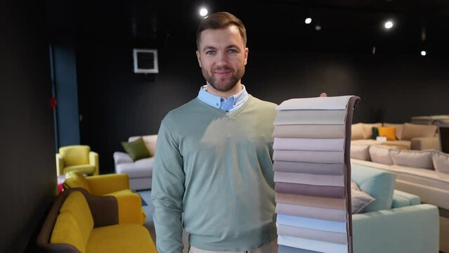 Seller with fabric and textiles samples in furniture store