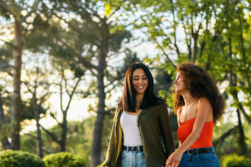 two young women couple walking in a park