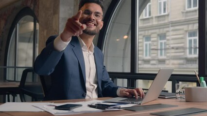 Indian business man manager CEO employer working laptop at corporate office workplace happy joyful Arabian male businessman pointing finger at camera hey you hand gesture positive cheerful guy smile - Powered by Adobe