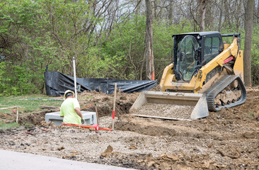 Worker Working on Corner Catch Basin in Drainage Trench