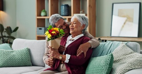 Old man, woman and surprise of flowers on couch or sofa, happy and couple in living room of house. Senior, male person and partner with gift for love, smile and happiness in home and retirement - Powered by Adobe