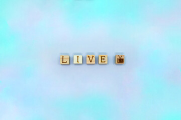 LIVEの英語とテレビマークのブロックが中心に並ぶまだらな薄紫の背景