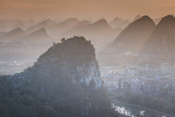 Limestone mountains at the sunset surrounded by city buildings, Guilin, China