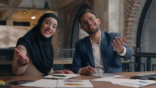 Multiethnic diverse male female office colleagues business partners muslim islamic woman in hijab Arabian man working together happy smiling businessman businesswoman invite come here welcome gesture