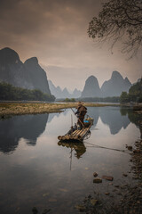 Cormorant fisherman and his bird on the Li River in Yangshuo, Guangxi, China.
