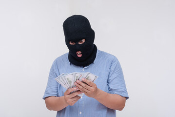 A criminal in a ski mask counting a stack of cash against a stark white background, evoking themes of crime and theft.