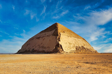 Bent Pyramid, built by the Pharoah Snefuru is the first example of a smooth side pyramid seen here against bright blue skies at the Dahshur necropolis at Cairo,Egypt
