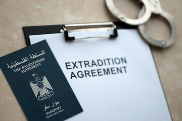 Passport of Palestinian Authority and Extradition Agreement with handcuffs on table close up