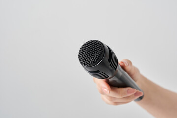 ワイヤレスマイクを持つ女性の手元
