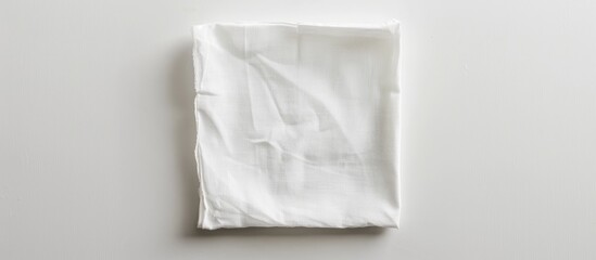 A white square bar napkin is separated on a white backdrop.