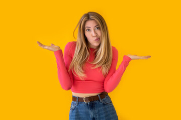 Image of a perplexed and surprised beautiful woman on a yellow background. 