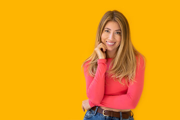 Portrait of a young Caucasian woman with pleasant smile and crossed arms isolated on yellow wall
