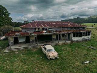 Abandoned car and building on farmland in Tikitiki, Gisborne, New Zealand. - obrazy, fototapety, plakaty