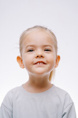Portrait of a little smiling girl on a gray background