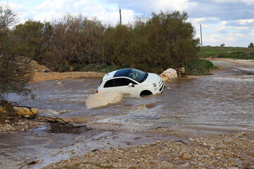 The car was carried away by a strong rain flow of water.