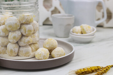 Kue putri salju or snow white cookies, popular hari raya cookies in Indonesia, baked and powdered with icing sugar. Special background for ramadan and eid mubarak. 