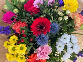 Herzlichen Glückwunsch mit einem bunten Blumenstrauß mit vielen verschiedenen Blumen in vielen...