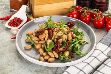 White canned beans with arugula and dry tomatoes