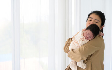 Cute newborn baby girl sleeping on mom shoulder next to white curtain window at home. Safe with mom hug and healthy newborn baby concept - 787814425