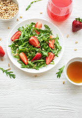 Fresh Strawberry Arugula Salad With Pine Nuts Served on a Bright Day