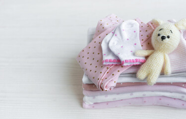 Fototapeta na wymiar Stack of baby clothes, socks and knitted toy