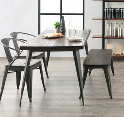 Casual morning dining scene in a contemporary space, with a textured dark wood table and bench,...