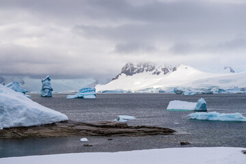 Giant iceberg and intriguinly shaped ice formation align the Coast of Charlotte Bay, as seen from...